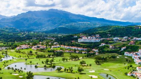 在鸟瞰波多黎各格兰德河畔的 Rio Mar Country Club 俱乐部鸟瞰高尔夫球场和迷人山景