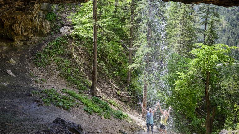 徒步旅行者精神饱满地攀爬到斯皮尔菲什峡谷的群落洞穴后，可以在瀑布下冲凉，舒缓身心。