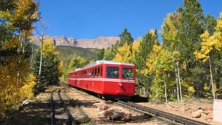 骑车沿布罗德莫派克峰齿轨铁路穿过风景迷人的白杨树林。 骑车沿布罗德莫派克峰齿轨铁路穿过风景迷人的白杨树林。