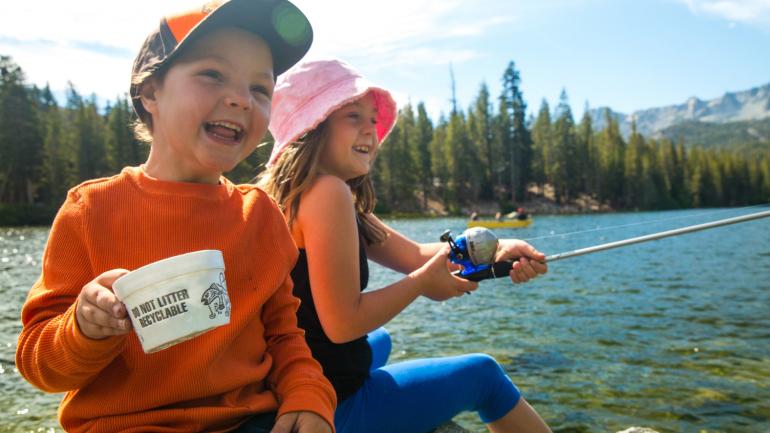 美丽的马麦斯湖上,孩子们从布满岩石的舒适场地抛竿垂钓 美丽的马麦斯湖上,孩子们从布满岩石的舒适场地抛竿垂钓