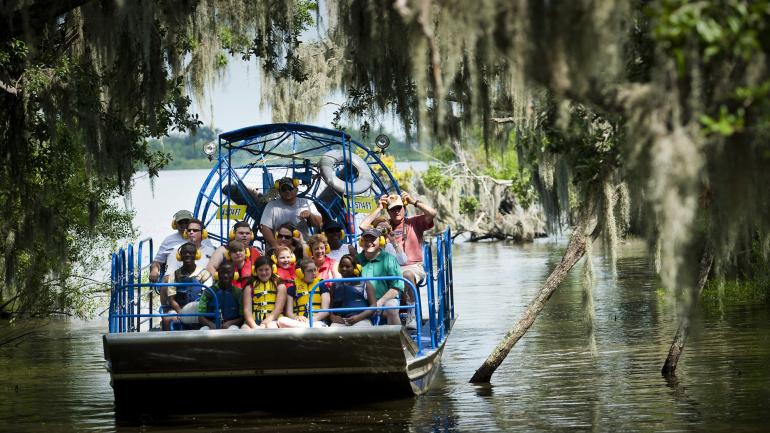 一群人在让拉菲特国家历史公园和自然保护区乘坐汽艇游览