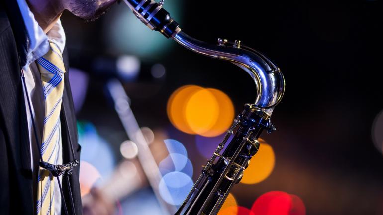 一个人在 Snug Harbor Jazz Bistro 爵士酒吧的现场爵士表演中吹奏萨克斯