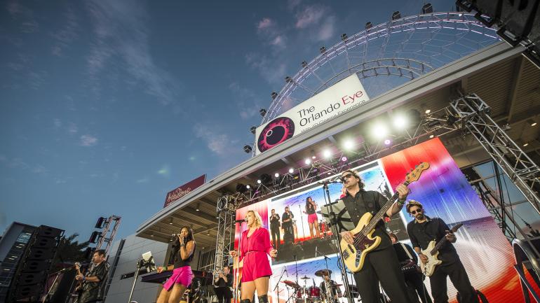 在奥兰多 I-Drive 360 表演节目的乐队,背后是奥兰多之眼 在奥兰多 I-Drive 360 表演节目的乐队,背后是奥兰多之眼