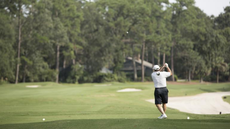 一名高尔夫球手正在尝试躲过海湾小镇林克斯高尔夫俱乐部内的沙土障碍 一名高尔夫球手正在尝试躲过海湾小镇林克斯高尔夫俱乐部内的沙土障碍