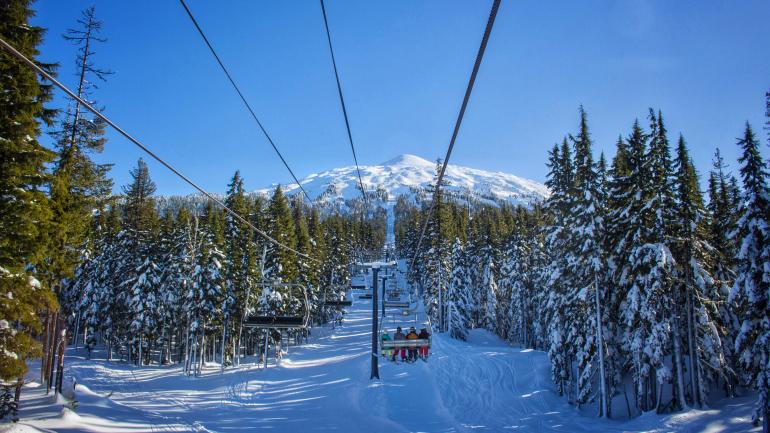 白雪皑皑的高山衬托着巴奇勒山滑雪场的滑雪缆车