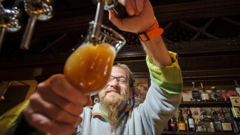 The Saranac Brewery 啤酒厂的调酒师正在倒啤酒