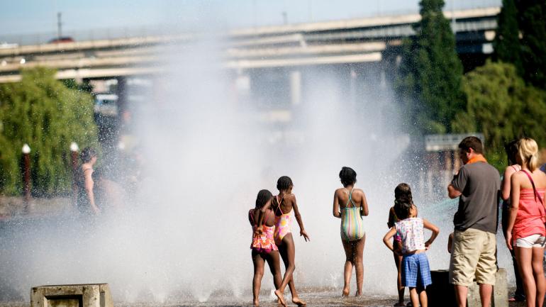 孩子们在水边公园中的一座喷泉旁玩耍