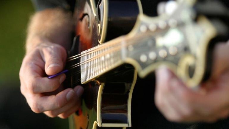 一个人正在弹奏曼陀林表演蓝草音乐的特写