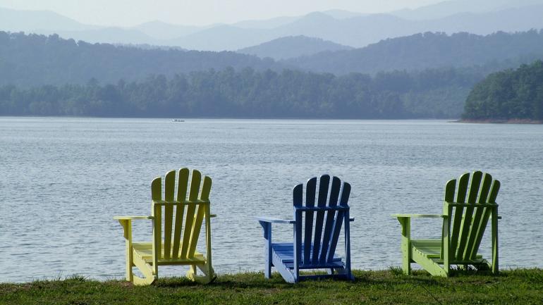 夏日的午后，摆放在湖边的三把彩色座椅