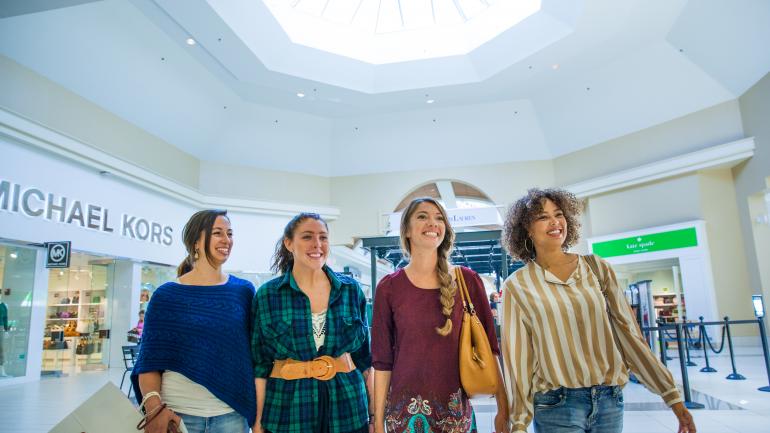 在奥特莱斯内的精品店逛街
