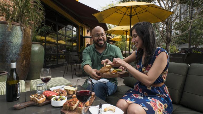 在亚利桑那州坦佩市中心的 Postino Annex 餐厅无忧无虑地享用午餐开胃菜和葡萄酒
