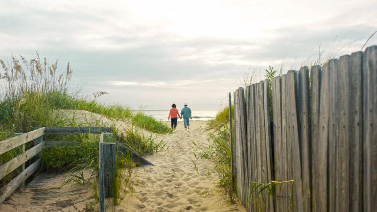 一对老夫妇在沙桥上欣赏日落 一对老夫妇在沙桥上欣赏日落