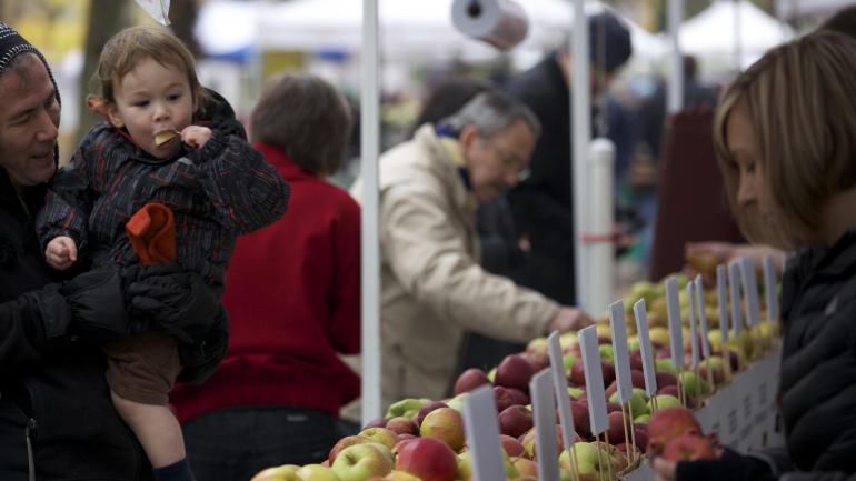 一个孩子在波特兰农贸市场吃苹果