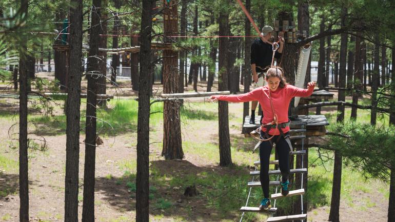 一名女孩正在穿越弗拉格斯塔夫的探险吊桥 一名女孩正在穿越弗拉格斯塔夫的探险吊桥