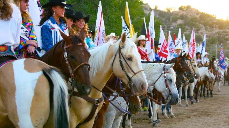 在普雷斯科特世界最古老的牛仔竞技活动大门入口处排队进场的女牛仔