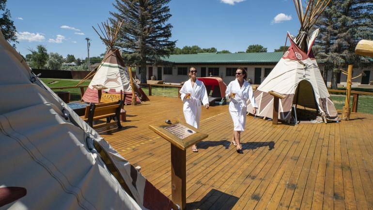 在怀俄明州萨拉托加温泉度假村浸泡温泉的间隙畅饮啤酒，放松身心