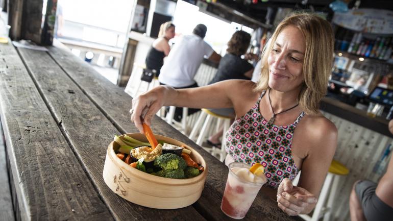 在海滩明信片旅馆，品一份健康的开胃菜和冰冻鸡尾酒，俯瞰整个海滩