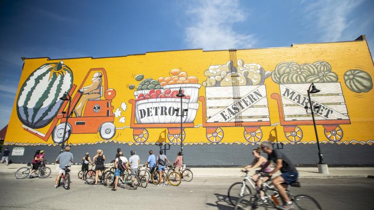 在密西根州底特律自行车之旅期间,在东部市场区停下欣赏艺术品 在密西根州底特律自行车之旅期间,在东部市场区停下欣赏艺术品