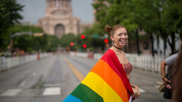 德克萨斯州国会大厦附近高举骄傲节旗帜的女孩