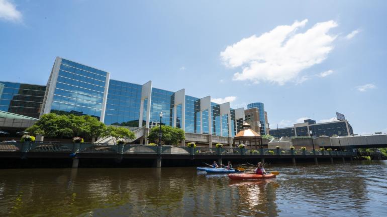 在格兰德河上划着皮划艇穿过兰辛市中心