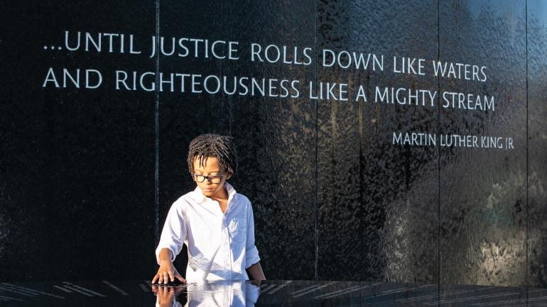 参观阿拉巴马州蒙哥马利民权纪念碑的男孩 参观阿拉巴马州蒙哥马利民权纪念碑的男孩