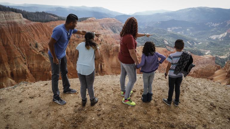 一家人在犹他州锡达布雷克斯国家保护区内欣赏红岩景观