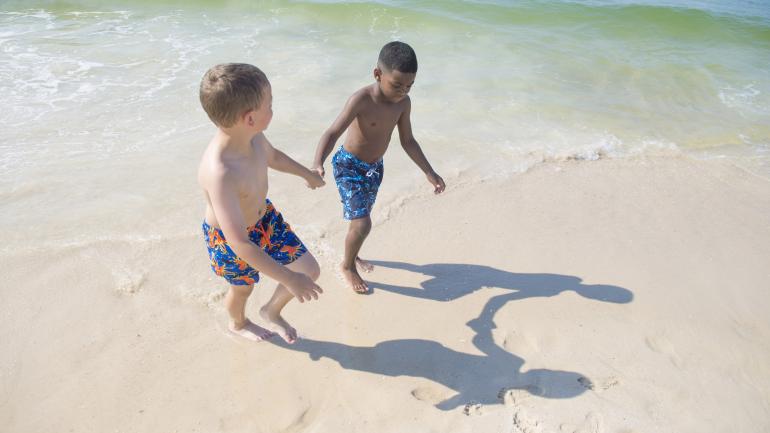 孩子们在海湾州立公园柔软的白色沙滩上玩耍