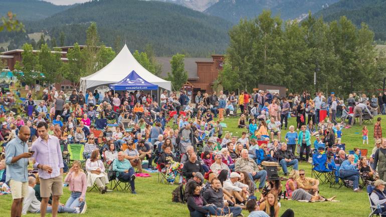 山地音乐节期间，人群聚集，聆听现场乐队演奏