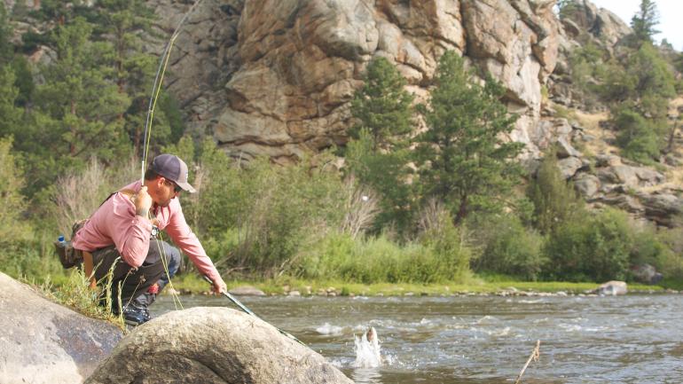 北普拉特河上垂钓者将上钩的鱼儿拖出水面的瞬间