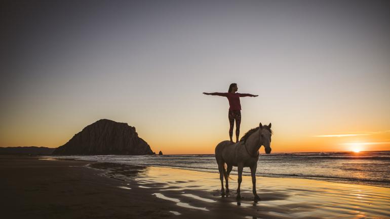 在加利福尼亚州圣路易斯-奥比斯波县的莫洛岩石美景映衬下体验马上瑜伽