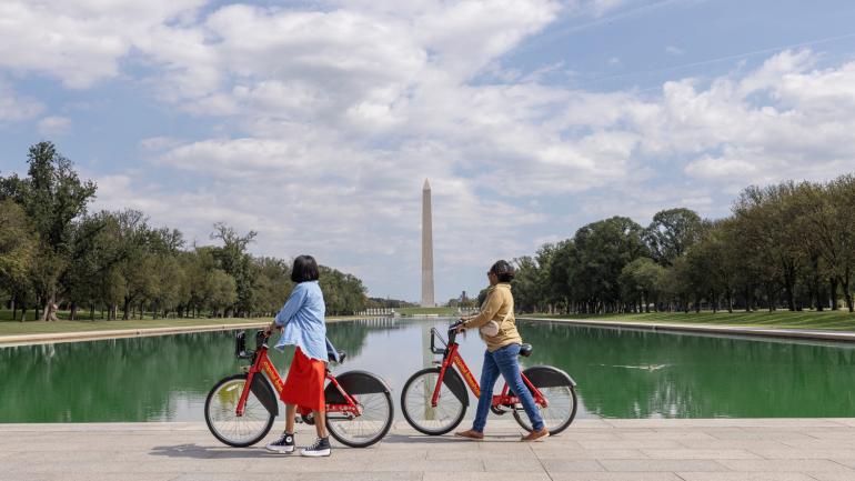 在华盛顿哥伦比亚特区的国家广场骑行兜风，背景矗立的是华盛顿纪念碑