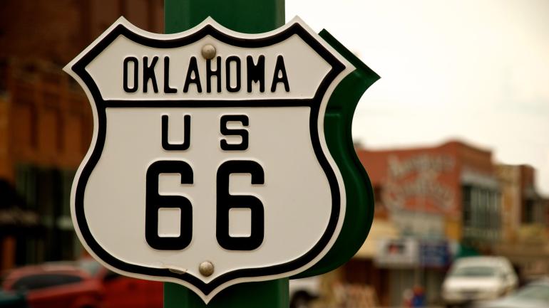 一块盾牌标志，象征着俄克拉荷马州历史悠久的 66 号公路的一个小镇路段
