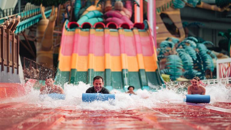 在梦工厂水上乐园的 Trolls Rainbow Racers 水上滑梯上飞驰而下