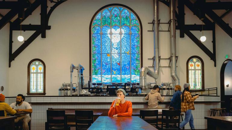 在 Steeplejack Brewing Company 啤酒厂品尝啤酒，其酒吧位于一座百年教堂建筑内