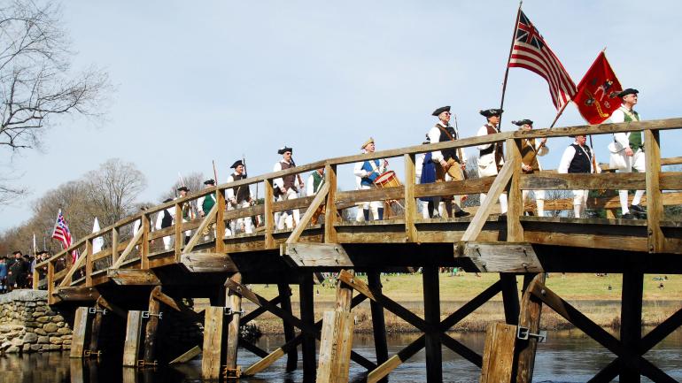 身穿戏服的历史爱好者在康科德北桥上重现美国独立战争的战斗场景