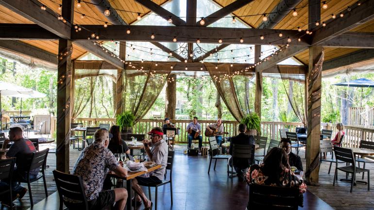 在斯莱德尔的 Palmettos on the Bayou 餐厅欣赏现场音乐表演，观赏 Bayou Bonfouca 河口的美景