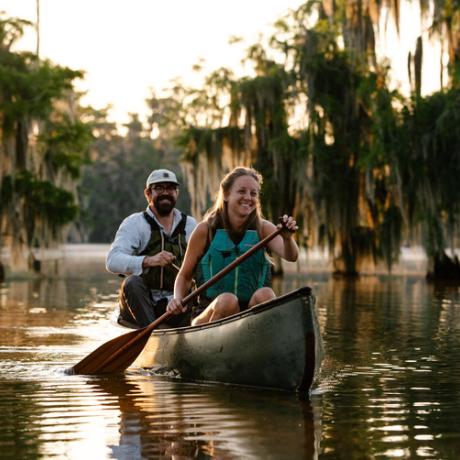 路易斯安那州布罗布里奇附近：湖上划独木舟的夫妇和湖畔的柏树林