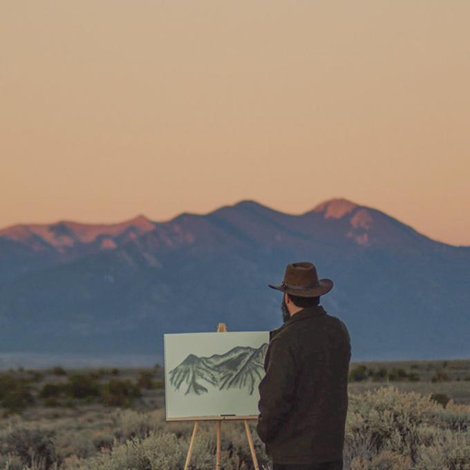 An artist in the field drawing the landscapes of New Mexico