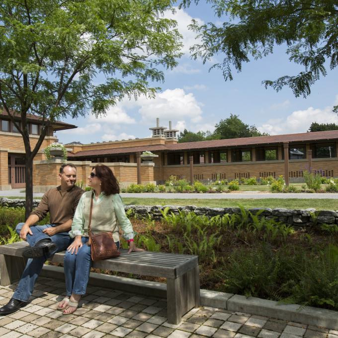 A couple sits outside Martin House, designed by Frank Lloyd Wright A couple sits outside Martin House, designed by Frank Lloyd Wright