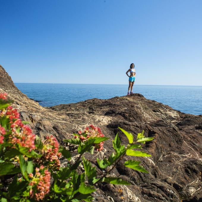 一名徒步旅行者站在密西根州马奎特的派斯克小岛公园的黑岩石顶 一名徒步旅行者站在密西根州马奎特的派斯克小岛公园的黑岩石顶