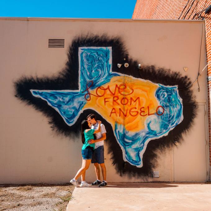 一对情侣在德克萨斯州圣安吉洛的公共艺术作品前拍照