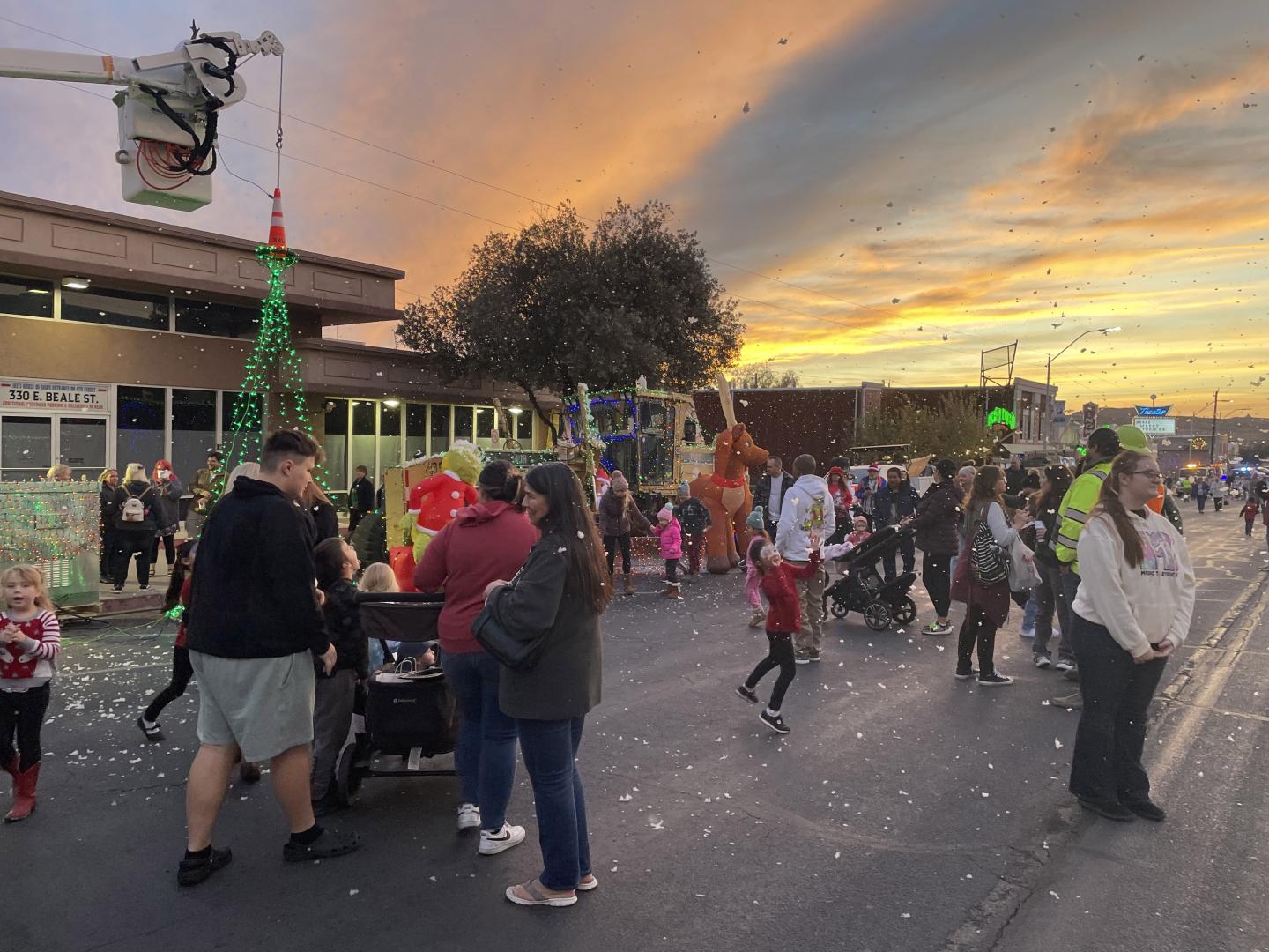 在亚利桑那州金曼市中心的 Very Merry Street of Lights 街道上欣赏节日灯饰与人造雪景的游客 在亚利桑那州金曼市中心的 Very Merry Street of Lights 街道上欣赏节日灯饰与人造雪景的游客