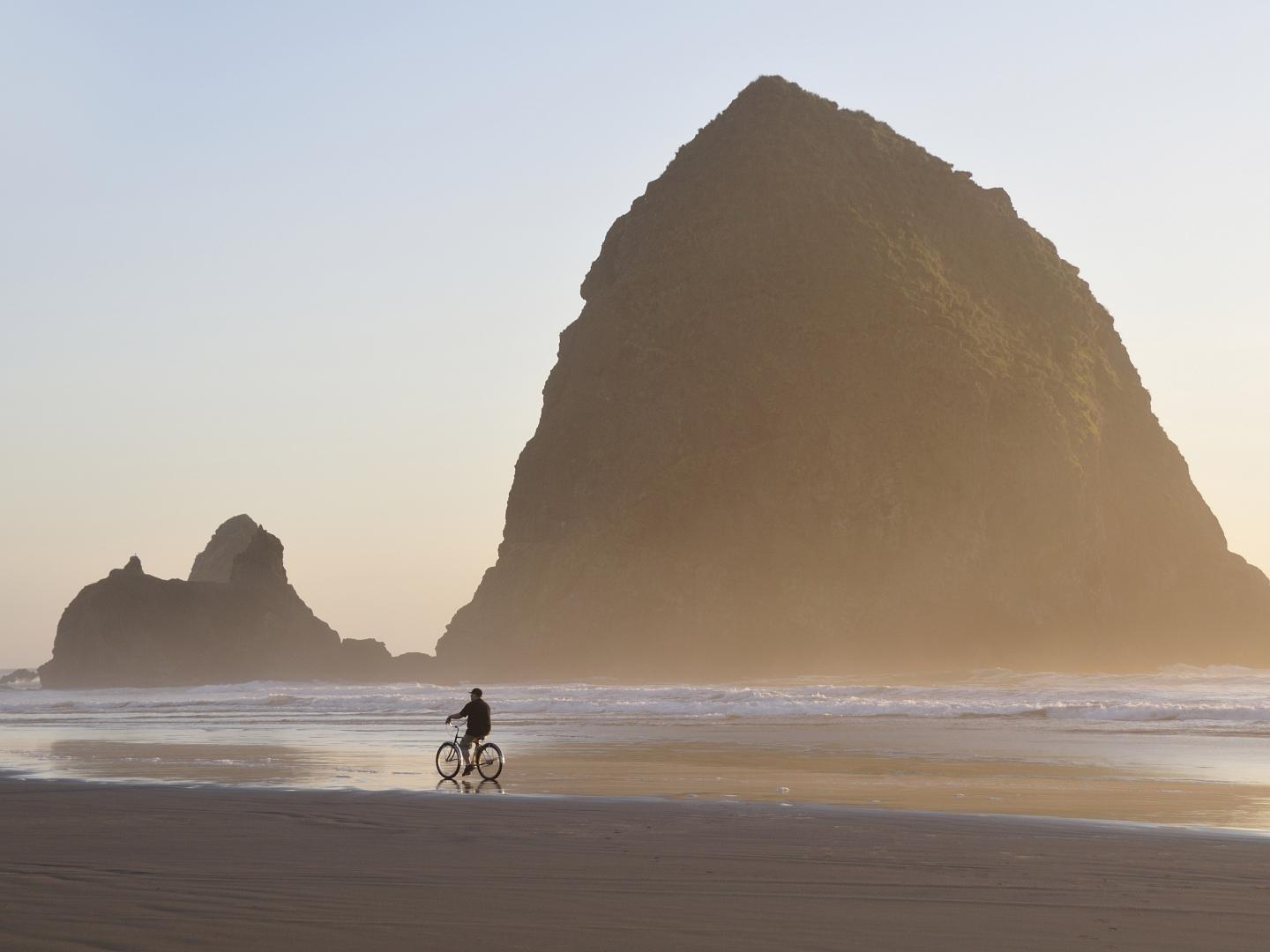 在坎农比奇草垛岩前骑自行车 在坎农比奇草垛岩前骑自行车