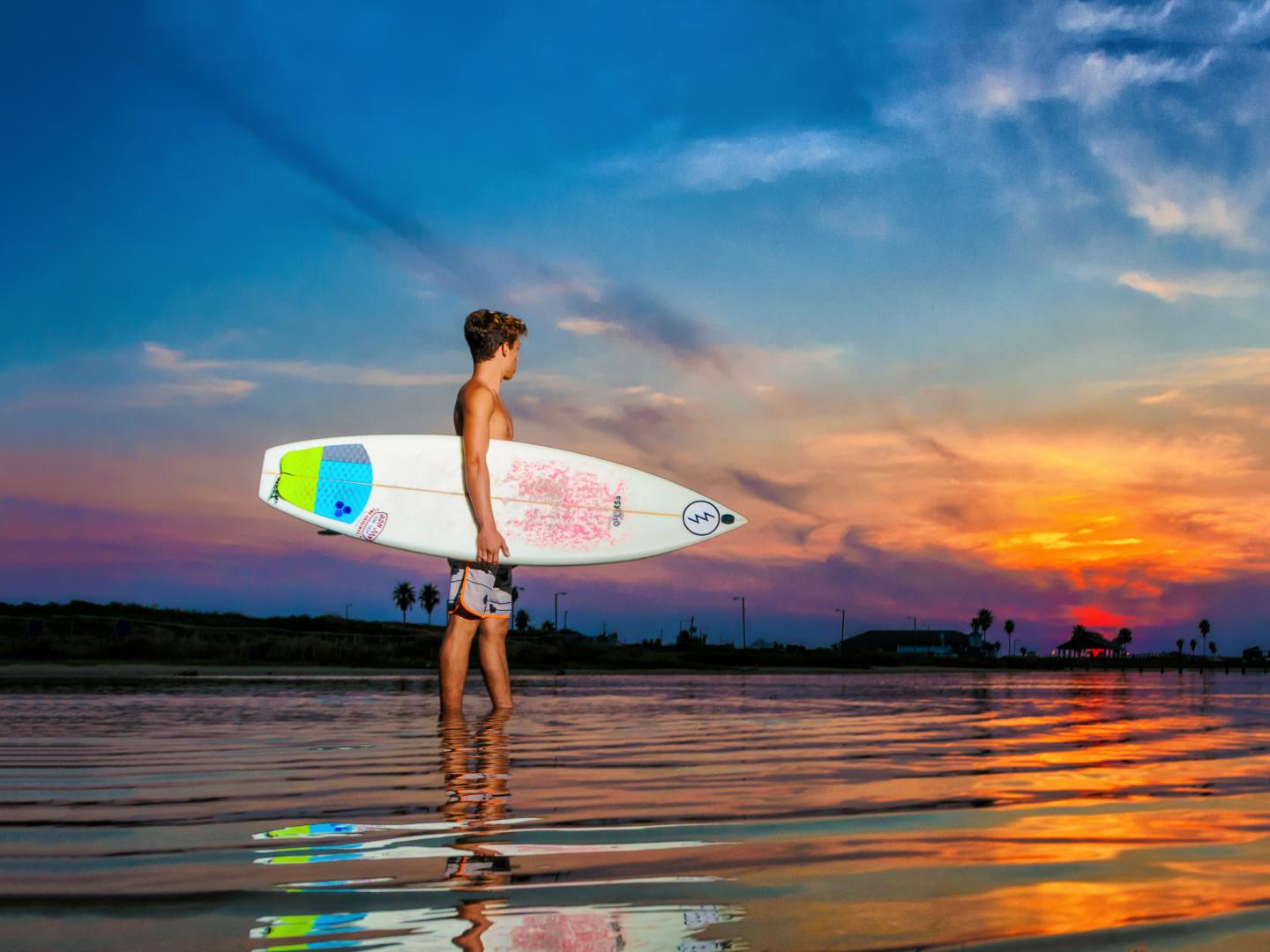 在德克萨斯州布拉佐斯波特的日出时分冲浪