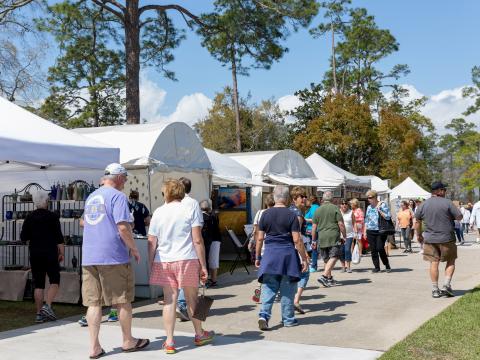 Patrons browsing artists’ tents at the Orange Beach Festival of Art in Alabama Patrons browsing artists’ tents at the Orange Beach Festival of Art in Alabama