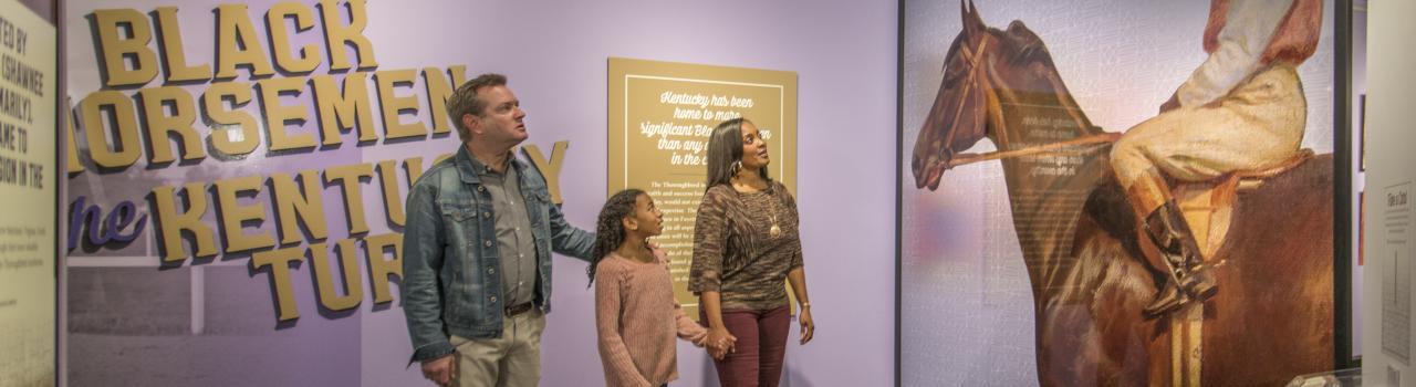 一家人正在参观肯塔基州列克星敦国际马匹博物馆的历史展品