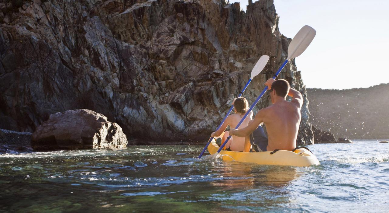 乘坐皮划艇划向一处岩石海湾