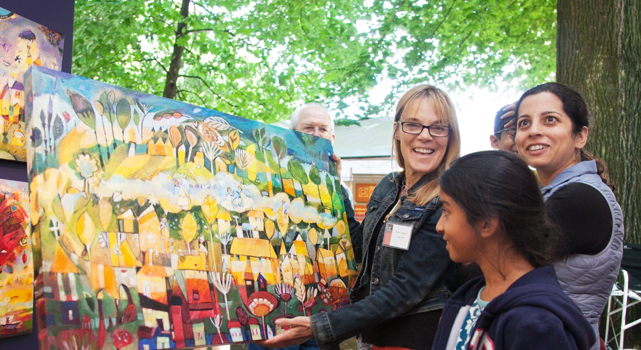 一位女士从俄勒冈州波特兰的本地艺术家那里购买一幅油画