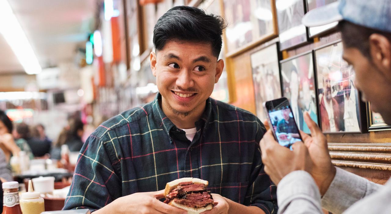 在纽约市著名的 Katz's Delicatessen 熟食店内咬一口美味的三明治 在纽约市著名的 Katz's Delicatessen 熟食店内咬一口美味的三明治
