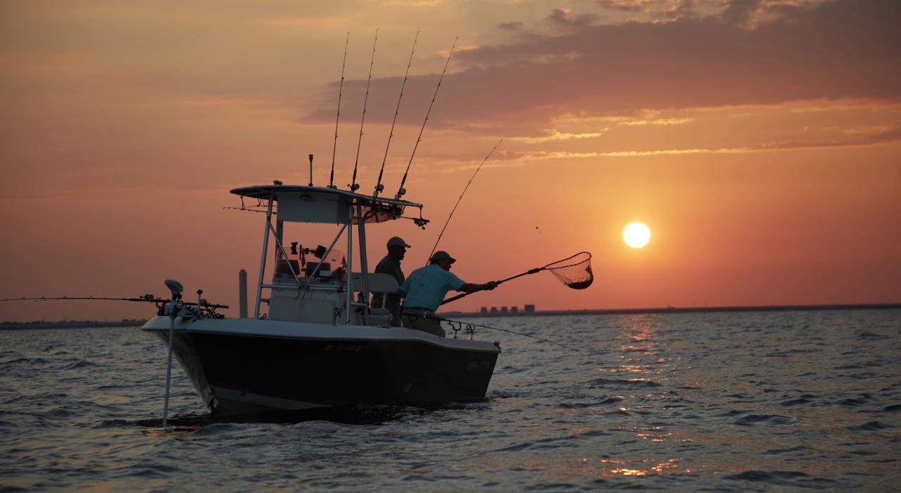 旭日东升，橙色光芒映照在默里湖的渔夫身上